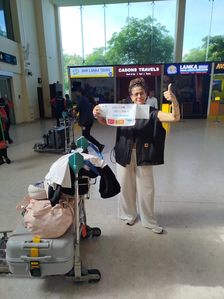 Happy tourist at airport with SMA welcome sign giving thumbs up